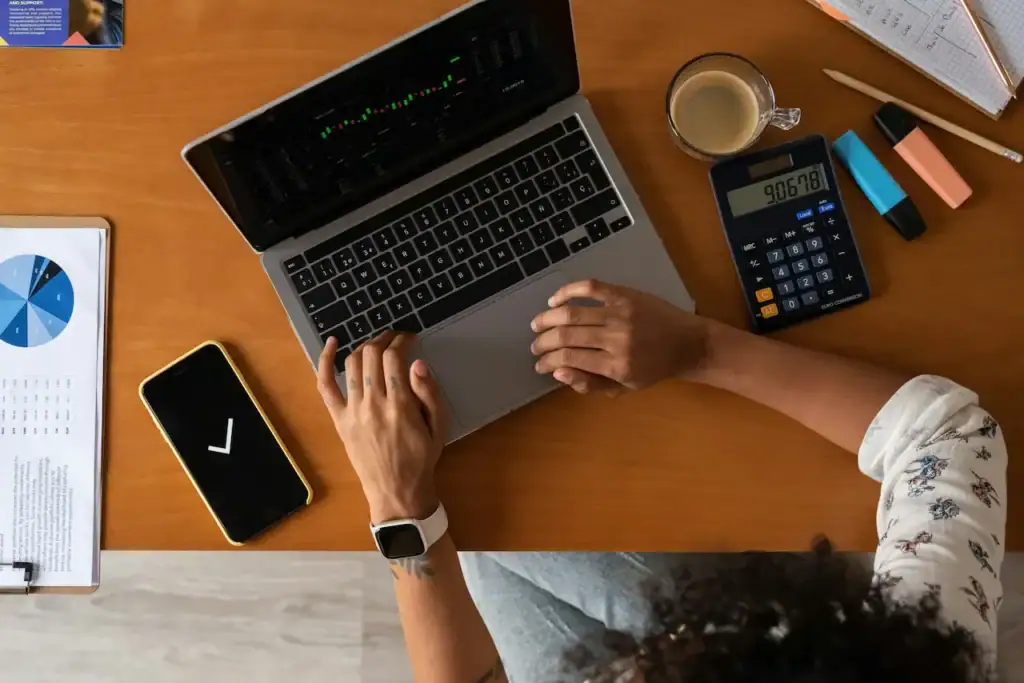 Employeur qui budgète son assurance collective pour PME, calculatrice et graphiques financiers à l'appui